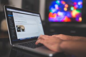 Une personne travaille sur un ordinateur portable, écran affichant une interface de gestion de contenu