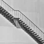 Escalier métallique en fer avec garde-corps, mur lisse, noir et blanc
